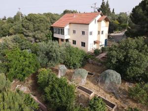an aerial view of a house with trees and rocks at הבית ליד הבוסתן דירה לזוג in Mikhmannim