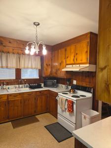 a kitchen with wooden cabinets and a white stove top oven at Brick House Retreat in Hamlet +51 photos