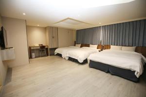 a hotel room with two beds and a television at Tai Shinu Hotel in Douliu +83 photos