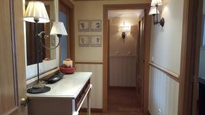 a hallway with a vanity with two lights and a mirror at Penthouse Beach Apartment in Cala de Finestrat