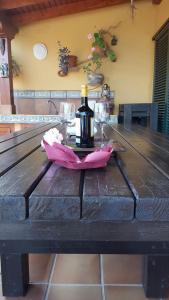 una mesa con una botella de vino y copas. en Villa Bruma Isabella, en Corralejo