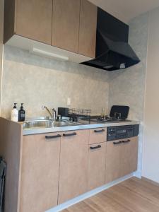 a kitchen with a sink and a stove at 南阿蘇サウナ5gaku G1 in Minami Aso