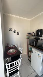 a kitchen with a small table and a refrigerator at PNZ Loft 2 in Petrolina