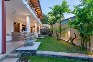 a courtyard of a house with trees and plants at OMA Hikkaduwa in Hikkaduwa