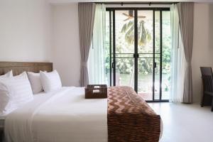 a bedroom with a bed and a large window at Tiger House River Kwai in Ban Tha Thong Mon