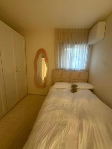 a small bedroom with a white bed with a window at Shemesh Boutique in Beit Shemesh +2 photos