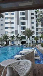 a swimming pool with chairs and a building at Sophisticated 1BR Unit w Panoramic Horizon View in Cebu City