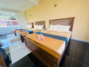 a group of four beds in a room at Adams Peak Lake Resort in Nallathanniya