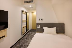 a bedroom with a large white bed and a mirror at Via Inn Prime Kumamoto in Kumamoto