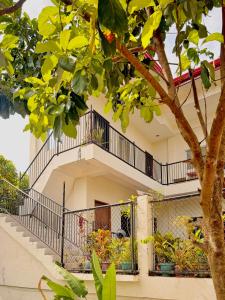 a building with a balcony and a tree at Brisa Room T in El Nido Airport