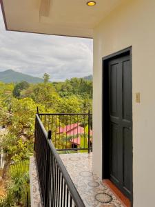 a balcony with a black door and a view at Brisa Room T in El Nido Airport +2 photos