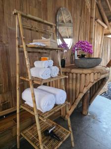 a stack of towels on a shelf in a bathroom at Sunrise Hill Bamboo House-Private Jungle Villa in Sidemen +71 photos