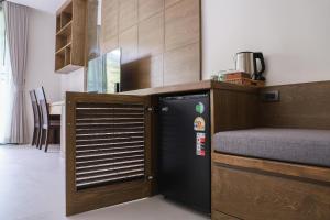 a kitchen with a black refrigerator in a room at Tiger House River Kwai in Ban Tha Thong Mon