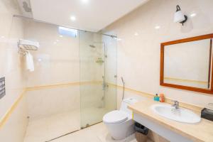 a bathroom with a shower and a toilet and a sink at Catinal Hotel in Danang
