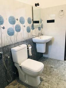 a bathroom with a toilet and a sink at The Vinza in Hikkaduwa