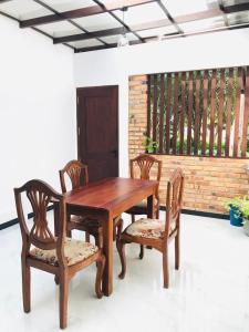 a wooden table and two chairs and a wooden table and chairs at The Vinza in Hikkaduwa
