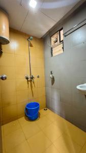 a bathroom with a blue bucket next to a sink at River Edge Resort & Café in Kumta