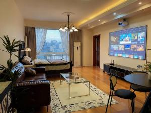 a living room with a couch and a large screen at Anju Apartment in Beijing