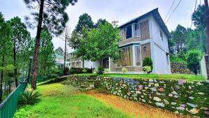 a house with a stone wall in front of a yard at Blue Pine Orchards in Lansdowne