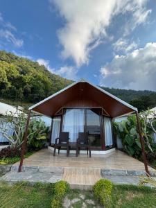 a gazebo with two chairs and a table at Surya Camp Buahan in Kubupenlokan
