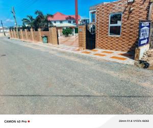 an empty street in front of a brick house at kimkeri hotel in Ogbojo
