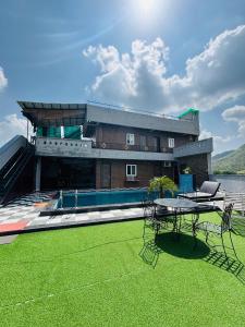 a house with a pool and a table on a lawn at Hill Touch Villa in Thūr