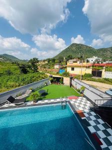 a swimming pool with a view of a house at Hill Touch Villa in Thūr