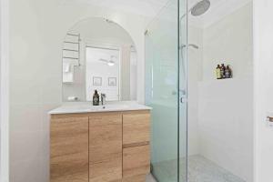 a bathroom with a sink and a glass shower at Casa LuCe by Experience Jervis Bay in Erowal Bay +15 photos