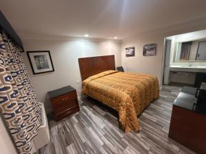 a bedroom with a bed and a dresser and a window at Crescent Motel, South Gate - Los Angeles in South Gate