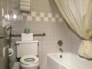 La salle de bains est pourvue de toilettes blanches et d'une baignoire. dans l'établissement Inn Town Motel, à Waupun