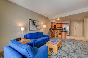 a living room with blue couches and a kitchen at Diamond Suite at Platinum Hotel in Las Vegas