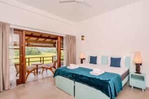 a bedroom with a large bed and a balcony at OMA Hikkaduwa in Hikkaduwa