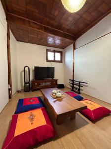 two beds in a room with a table and a tv at Gilgaon Hanok Stay in Seoul