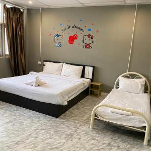 a bedroom with two beds with hello kitty stickers on the wall at Saran Hotel krabi Thailand in Krabi