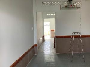 a ladder in a room with a white wall and a hallway at TuNo Homestay in Tuy Hoa