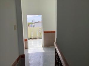 a hallway of a bathroom with a mirror and a tile floor at TuNo Homestay in Tuy Hoa +19 photos