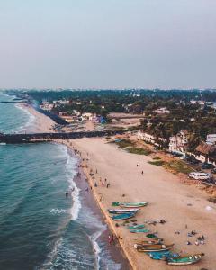 a beach with people and boats in the water at Nature Retreat Stay in Pondicherry