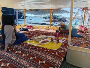 a group of people sitting at a table on a boat at Aswan all-inclusive private felucca in Aswan