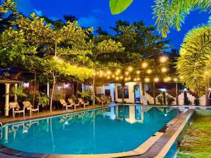 a swimming pool in a resort at night at Trinco Star Cabana in Trincomalee