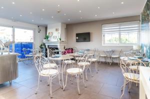a restaurant with tables and chairs and a fireplace at Hôtel CASABELLA Cannes Mouans Sartoux in Mouans-Sartoux