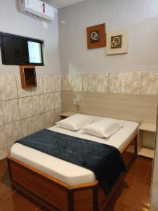 a bedroom with a bed and a flat screen tv at Hotel Anoitecer - 100 metros metrô Carandiru, 700 metros Rodoviária do Tietê, 900 metros Aeroporto Campo de Marte, 1,4 km Expor center norte, 1,8 km Distrito do anhembi! Oferecemos como cortesia café da manhã e estacionamento! in São Paulo