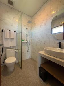 a bathroom with a toilet and a sink and a shower at Ngijeng Villa in Saba +6 photos