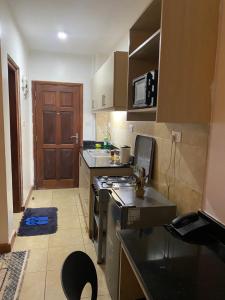 a small kitchen with a stove and a sink at West suites kisauni road in Nairobi