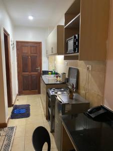 a small kitchen with a stove and a sink at West suites kisauni road in Nairobi