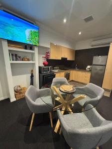 a kitchen with a table and chairs and a tv at Hobart Central Retreat in Hobart
