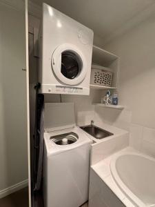 a kitchen with a washing machine and a sink at Hobart Central Retreat in Hobart