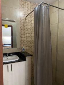 a bathroom with a shower curtain and a sink at West suites kisauni road in Nairobi