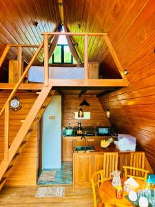 a kitchen and dining room in a wooden cabin at Eco Cabana Bellwood Kandy in Kandy
