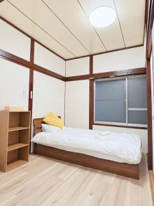 a bedroom with a bed and a window at はつはな in Osaka