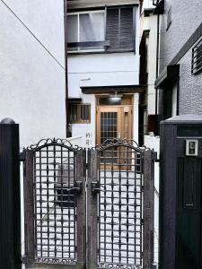 an entrance to a house with an iron gate at はつはな in Osaka